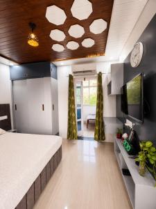 a bedroom with a bed and a tv on a wall at RK Homes in Delhi