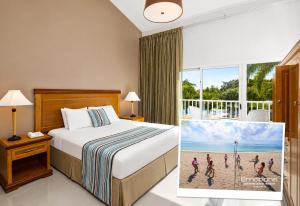a hotel room with a bed and a large window at Hodelpa Garden Suites - All Inclusive in Juan Dolio +48 photos