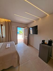 a bedroom with a bed and a flat screen tv at AVRA Apartments & Studios in Frý