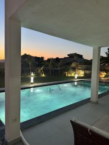 a large swimming pool with a sunset in the background at Luxurious Villa in Cesme with private pool in Çeşme