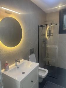 a bathroom with a sink and a shower and a toilet at Luxurious Villa in Cesme with private pool in Çeşme +24 photos