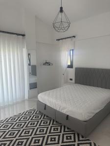 a white bedroom with a bed and a black and white rug at Luxurious Villa in Cesme with private pool in Çeşme