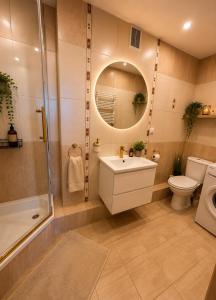 a bathroom with a sink and a toilet and a shower at Classic Apartment in Konin