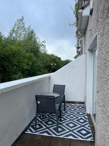 two chairs and a table on a balcony at Large 3 bed Duplex Apartment - Rhebogue Limerick in Limerick