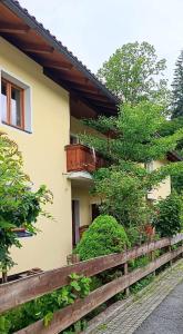 a house with a wooden fence in front of it at Ferienwohnung Eckschlager in Kössen