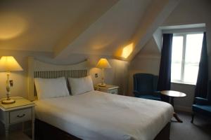 ein Hotelzimmer mit einem großen Bett und einem Fenster in der Unterkunft WatersEdge Hotel in Cobh + 23 Fotos