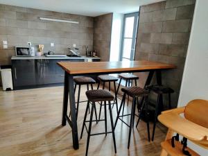 a kitchen with a wooden table and stools at Le Grand Stanislas in Nancy +3 photos