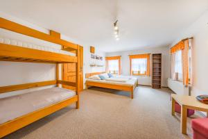 a bedroom with two bunk beds and a couch at Apartmány Koloniál in Rokytnice nad Jizerou