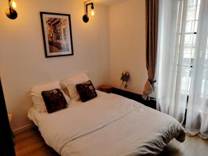 a bedroom with a bed with two pillows on it at Le Grand Stanislas in Nancy