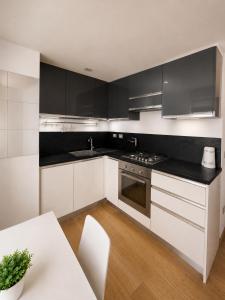 a kitchen with black and white cabinets and a table at Domus Turrita in Bologna