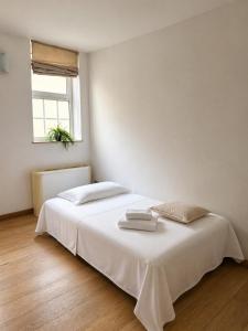 a white bedroom with a bed with two towels on it at Domus Turrita in Bologna