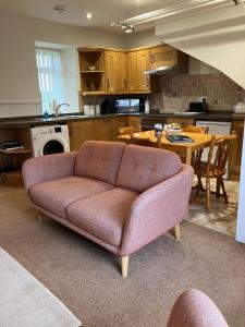 a living room with a couch in a kitchen at Westlea Cottage in Turriff
