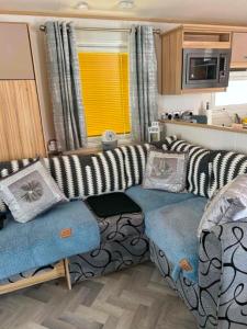 a living room with a couch and a table in a caravan at The Pointon-Bordeaux Caravan Co in Rhyl