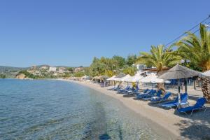 a beach with chairs and umbrellas and the water at Μeltemi in Glida