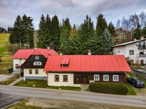 a house with a red roof on a street at Apartmány Koloniál in Rokytnice nad Jizerou