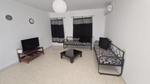 a living room with two couches and a tv at Menzel Rayan in Midoun