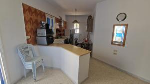 a kitchen with a counter and a chair in a room at Menzel Rayan in Midoun +14 photos