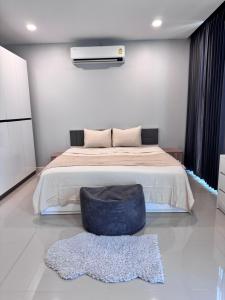 a bedroom with a large bed with a blue ottoman at Serenity Banna in Ban Huai Yai