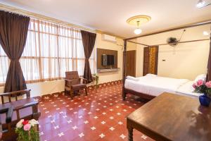 a hotel room with a bed and a table at Krish Inn in Chidambaram