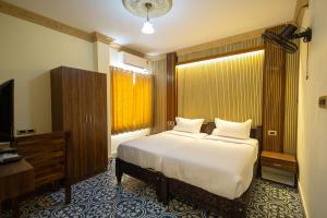 a bedroom with a bed and a television in it at Krish Inn in Chidambaram +7 photos