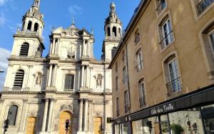 an old building with two towers with a clock on it at Le Grand Stanislas in Nancy