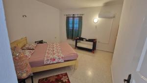 a small bedroom with a bed and a window at Menzel Rayan in Midoun