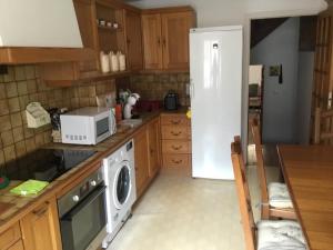 a kitchen with a white refrigerator and a microwave at Maison des barrys in Ispagnac