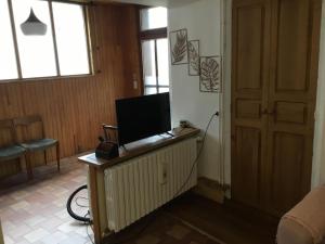 a room with a desk with a television on it at Maison des barrys in Ispagnac