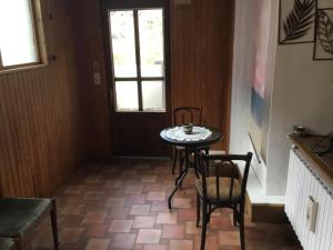a small table and chairs in a room with a window at Maison des barrys in Ispagnac +5 photos