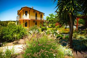 a yellow house with a balcony in a garden at Il Castello di Modolo in Modolo
