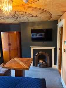 a living room with a fireplace with a tv above it at Durham Central Suites in Gilesgate