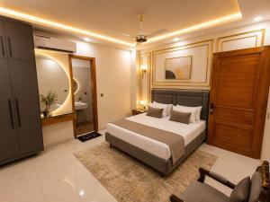 a bedroom with a king sized bed and a couch at City Rooms in Karachi