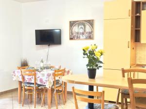 a dining room with a table and a tv on the wall at Viola House in Villasimius