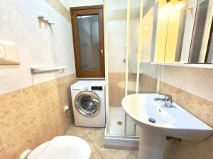 a bathroom with a washing machine and a sink at Viola House in Villasimius +30 photos