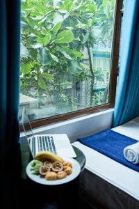 a plate of food on a table with a laptop at Ha Noi Capital Boutique Hotel in Hanoi