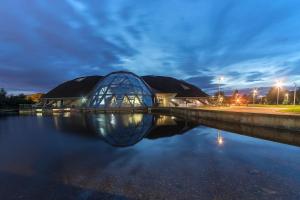 a building with a glass dome next to a body of water at Park Cottage in Scunthorpe