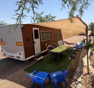 a caravan with a table and chairs and a tent at קרוואן על הים in Eilat