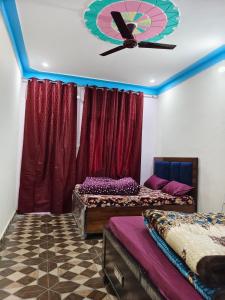 a room with two beds and a clock on the ceiling at Himalayan due lodge chopta in Sari