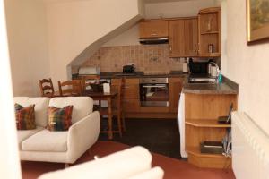 a kitchen with a couch and chairs in a room at Eastwood Cottage in Turriff