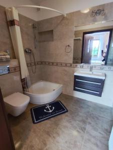 a bathroom with a toilet and a tub and a sink at Willa Hydrograf - rowery i parking bezpłatnie in Ustka