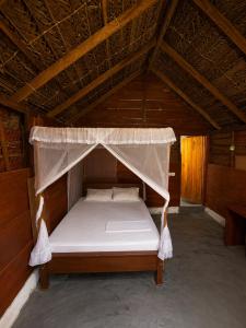 a bed in the attic of a wooden building at once more hostel in Pottuvil