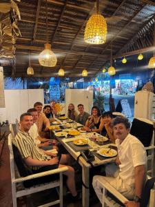 a group of people sitting around a table eating at once more hostel in Pottuvil +26 photos