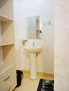 a bathroom with a sink and a mirror at Bliss Apartments in Nakuru