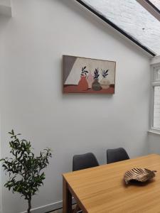 a dining room with a table and a painting on the wall at Sand Castle in Weymouth