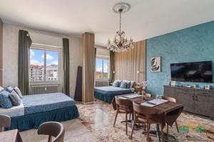 a room with two beds and a table and a tv at MILANO Bicocca Niguarda a 15min dal DUOMO in Milan