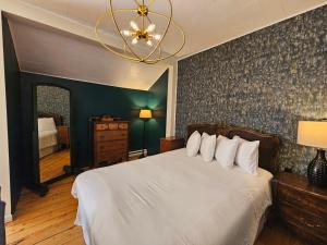 a bedroom with a bed and a chandelier at Auberge Lever L'Ancre in Sainte-Hélène-de-Kamouraska