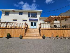 a house with a wooden fence and stairs in front at Auberge Lever L'Ancre in Sainte-Hélène-de-Kamouraska