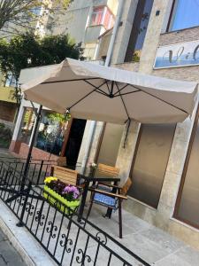 a table with an umbrella in front of a building at Vila Rosa Maria in Mangalia
