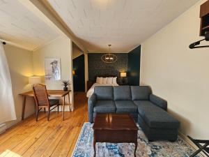 a living room with a couch and a bed at Auberge Lever L'Ancre in Sainte-Hélène-de-Kamouraska +16 photos
