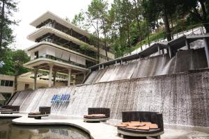 a pool with chairs sitting on top of a waterfall at HeHa Waterfall Suites & Camping Ground in Paragajen